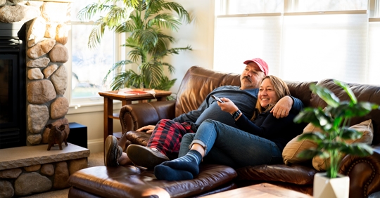 man and woman cuddling on a couch