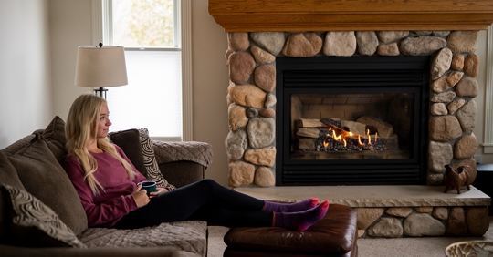woman sitting on couch next to fireplace